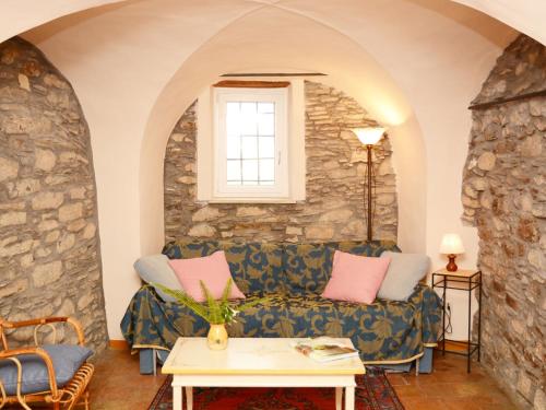a living room with a couch and a stone wall at Apartment Le Volte by Interhome in Valloria