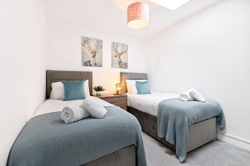 Un dormitorio con dos camas con toallas encima. en Spacious 3 Bed - Smart TVs - Great for Work Stays, en Swansea