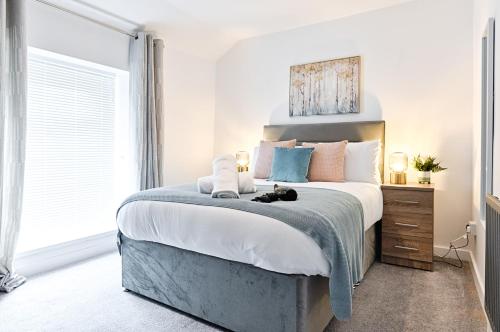 a bedroom with a large bed with a cat laying on it at Spacious 3BR Home in Swansea in Swansea