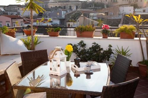 una mesa y sillas en un balcón con flores en Apartment Papyri, en Palermo