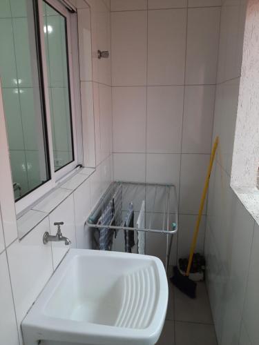 a bathroom with a white sink and a mirror at Cristal Boraceia IV apto 28 - check-out 15h in Bertioga
