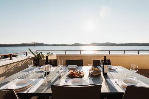 a table with wine glasses and a plate of food on a boat at Armerun Heritage Hotel & Residences in Šibenik