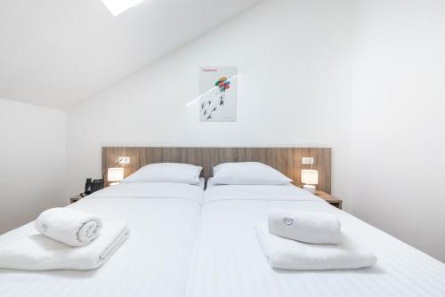 a white bed with two white towels on it at Dubrovnik Central Accommodation in Dubrovnik