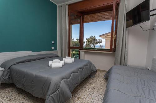 1 Schlafzimmer mit 2 Betten und einem großen Fenster in der Unterkunft AD UN PASSO DAL MARE in Praia a Mare