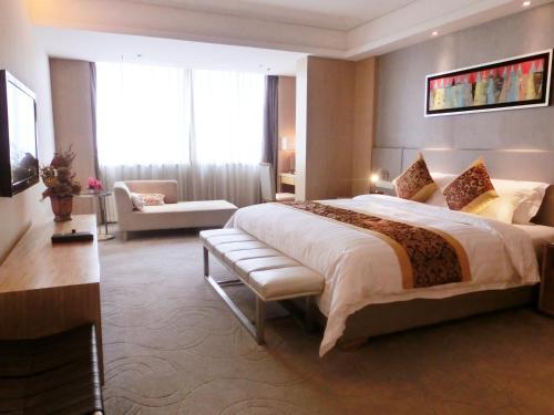 広州市にあるPearl River International Hotel（International Textile City）の大きなベッドとソファが備わるホテルルームです。
