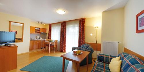 - un salon avec un canapé, une télévision et une table dans l'établissement Haus Birgit, à Bad Füssing