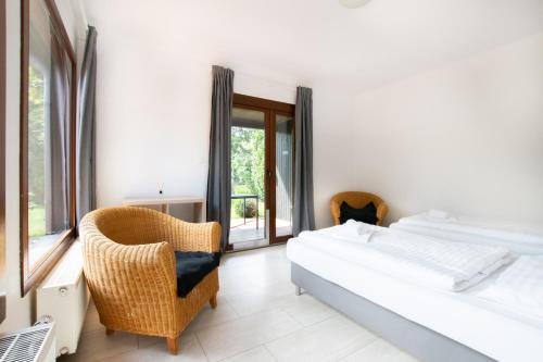 um quarto com 2 camas, uma cadeira e uma janela em RAJ Living - 6 Room Villa with Garden - 15 Min Messe DUS & Airport DUS em Meerbusch