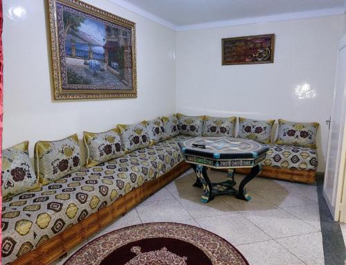 uma sala de estar com um sofá e uma mesa em Appartement Hamria RiF em Meknès