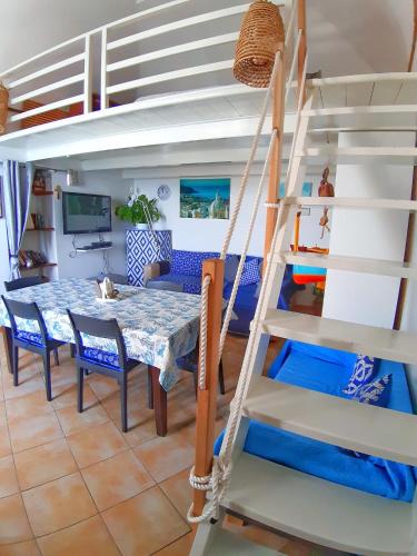 a room with a dining table and a loft bed at La Casa Azzurra in Procida