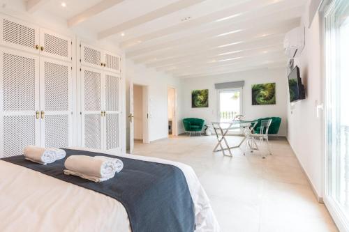 ein weißes Schlafzimmer mit einem Bett und einem Esszimmer in der Unterkunft Can Maties in Santa Margalida