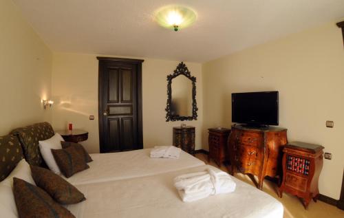 a hotel room with two beds and a tv at Palmariva Beach Hotel in Eretria