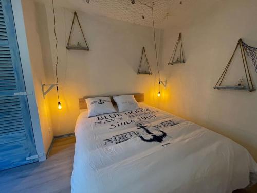 um quarto com uma cama com lençóis brancos e luzes em Ocean ROOM em Romans-sur-Isère