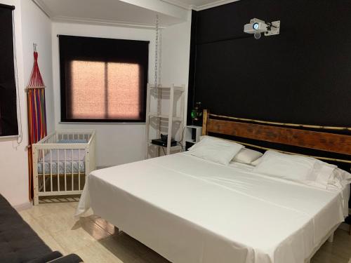 a bedroom with a large white bed with a black wall at Apartamento en Playa de Samil in Vigo