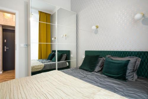 sypialnia z łóżkiem i dużym lustrem w obiekcie Glamorous Apartment Old Town Cracow w Krakowie