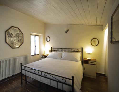 um quarto com uma cama e dois relógios na parede em La Chicca piccola casina in affitto nel Borgo Antico di Gaggio Montano BO em Gaggio Montano