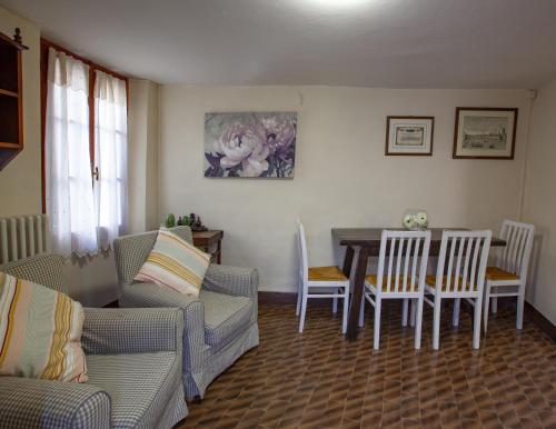 uma sala de estar com um sofá, uma mesa e cadeiras em La Chicca piccola casina in affitto nel Borgo Antico di Gaggio Montano BO em Gaggio Montano