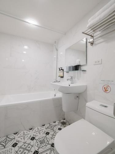 a white bathroom with a toilet and a sink at Hotel attic in Taipei