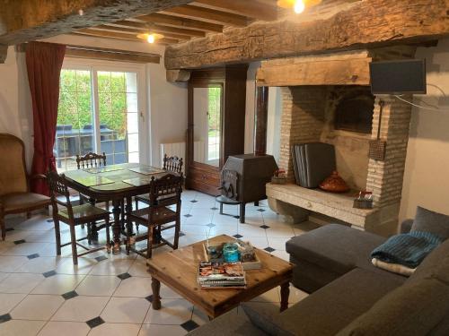un salon avec une table et une cheminée dans l'établissement Domaine de Villateux, à Terjat