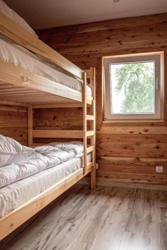 a bedroom with two bunk beds and a window at Domek Pod Świerkami in Sorkwity