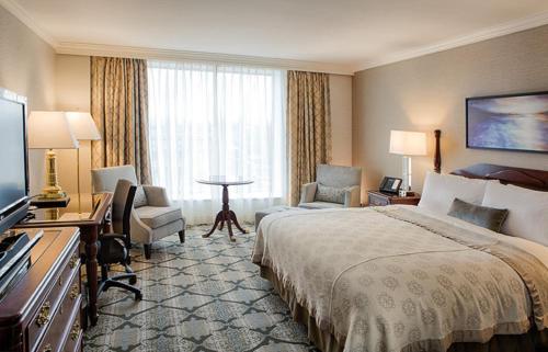 a hotel room with a bed and a television at The Magnolia Hotel & Spa in Victoria