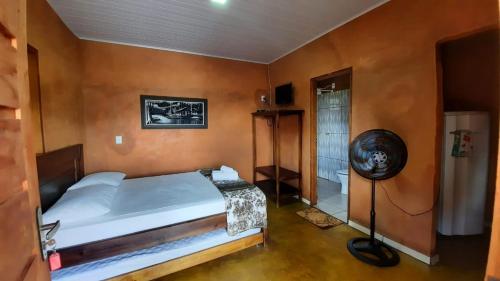 a bedroom with a large bed and a fan at Quinta do Vale in Pirenópolis