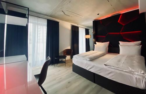 - une chambre avec un grand lit et une tête de lit rouge dans l'établissement DORMERO Hotel Aschaffenburg, à Aschaffenbourg