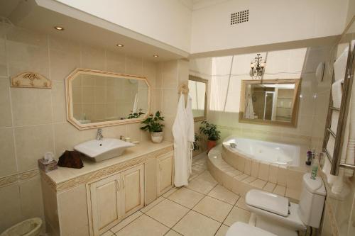a bathroom with a tub and a sink and a toilet at Bordeaux Haven Guest House in Vereeniging