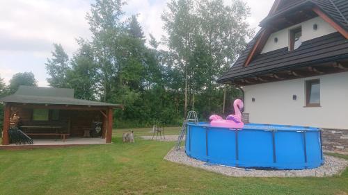 a house with a large blue tub in the yard at Jurgowski Domek in Jurgów
