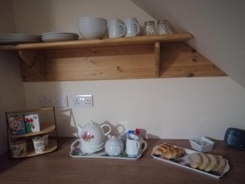 een keukenblad met borden, kopjes en croissants bij Corrie View in Invergarry