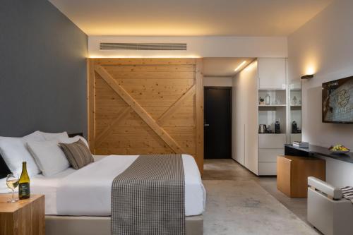a bedroom with a large bed and a wooden door at Kfar Giladi Hotel in Kefar Gil‘adi
