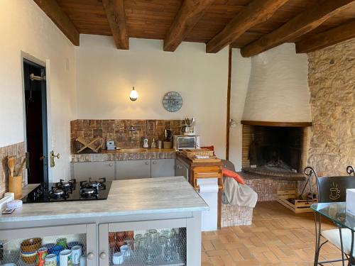 Il comprend une cuisine équipée d'une cuisinière et d'une cheminée en pierre. dans l'établissement Petite Maison en Périgord Noir, à Plazac