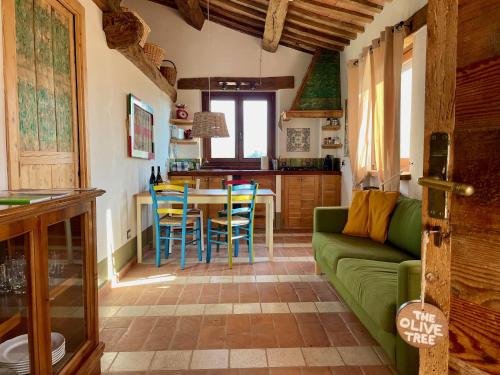 Una sala de estar con un sofá verde y una mesa. en La Corte del Gusto LuxuryApartments, en Arcevia