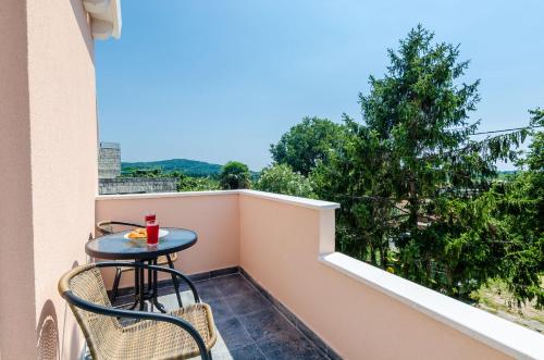 a small table and chairs on a balcony with a view at Apartments Dubrovnik Airport in Čilipi