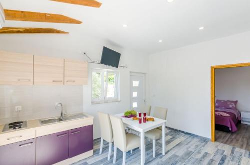 a kitchen with a table with chairs and a sink at Apartments Dubrovnik Airport in Čilipi