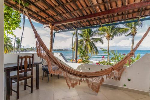 a hammock in a dining room with a view of the ocean at Pousada Aguas Marinhas in Cabo de Santo Agostinho