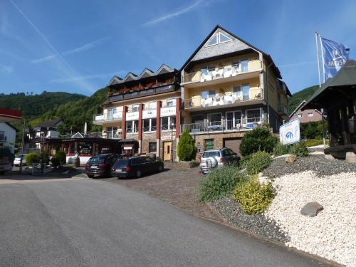 a large building with cars parked in front of it at Wein- und Gästehaus St. Aldegundishof in Sankt Aldegund