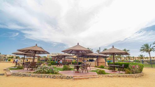 a group of tables and chairs with umbrellas on the beach at Blend Elphistone Resort Marsa Alam in Abu Dabab