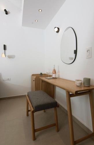 a dressing table with a stool and a mirror at IADES suites in Afitos