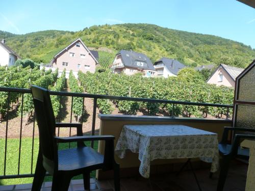a table and chairs on a balcony with a view at Wein- und Gästehaus St. Aldegundishof in Sankt Aldegund