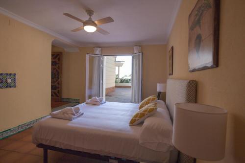 a bedroom with a bed with a ceiling fan at Santa Catalina Home in Málaga