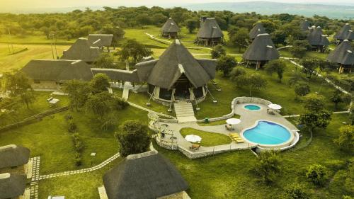 an aerial view of a village with a house with a pool at Kigambira Safari Lodge in Bakijurura