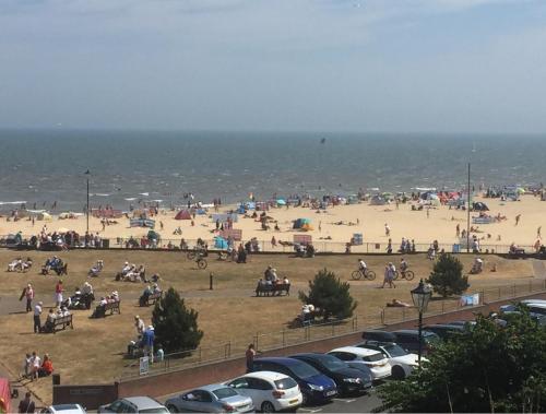a group of people on a beach near the ocean at Pier Road Holiday Home in Gorleston-on-Sea