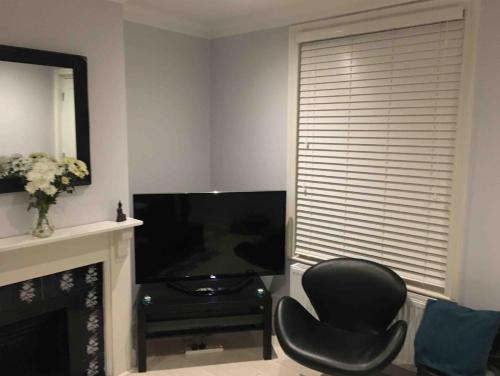 a living room with a chair and a television at Pier Road Holiday Home in Gorleston-on-Sea