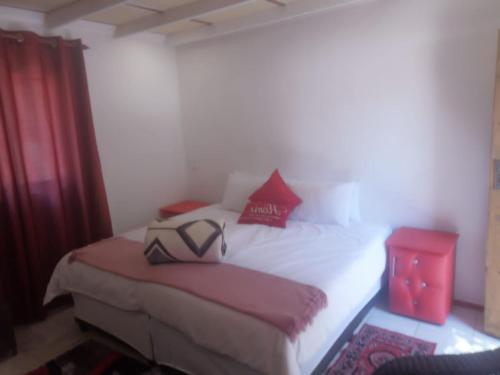 Un dormitorio con una cama con dos zapatos. en ConcordiaVOC, en Lanseria