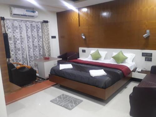 a bedroom with a bed and a chair in a room at GRAND Meridian in Pyāpali