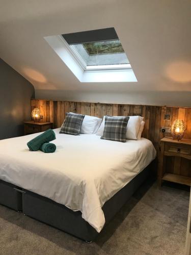a bedroom with a large white bed with a skylight at Rostrevor Mountain Lodge - Glamping Pods - Revive Sauna & Hot Tubs in Rostrevor