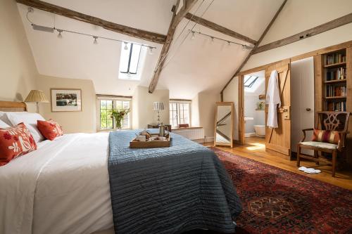 a bedroom with a large bed with a blue blanket at The Hayloft in Kings Cliffe