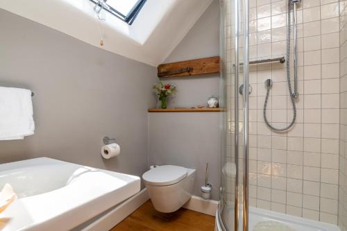 a bathroom with a shower and a toilet and a sink at The Hayloft in Kings Cliffe