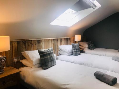 a room with three beds and a skylight at Rostrevor Mountain Lodge - Glamping Pods - Revive Sauna & Hot Tubs in Rostrevor