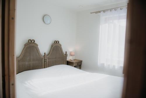 a bedroom with a white bed and a window at Résidence Sunêlia Les Logis d'Orres in Les Orres